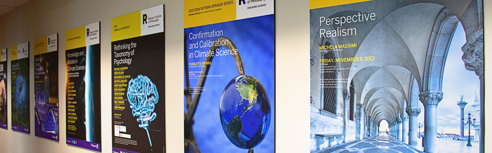 Previous Rotman event posters are displayed on the wall along the hallway